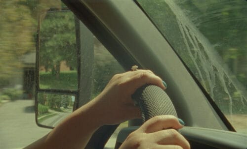 A closeup of a woman's hands on a steering wheel